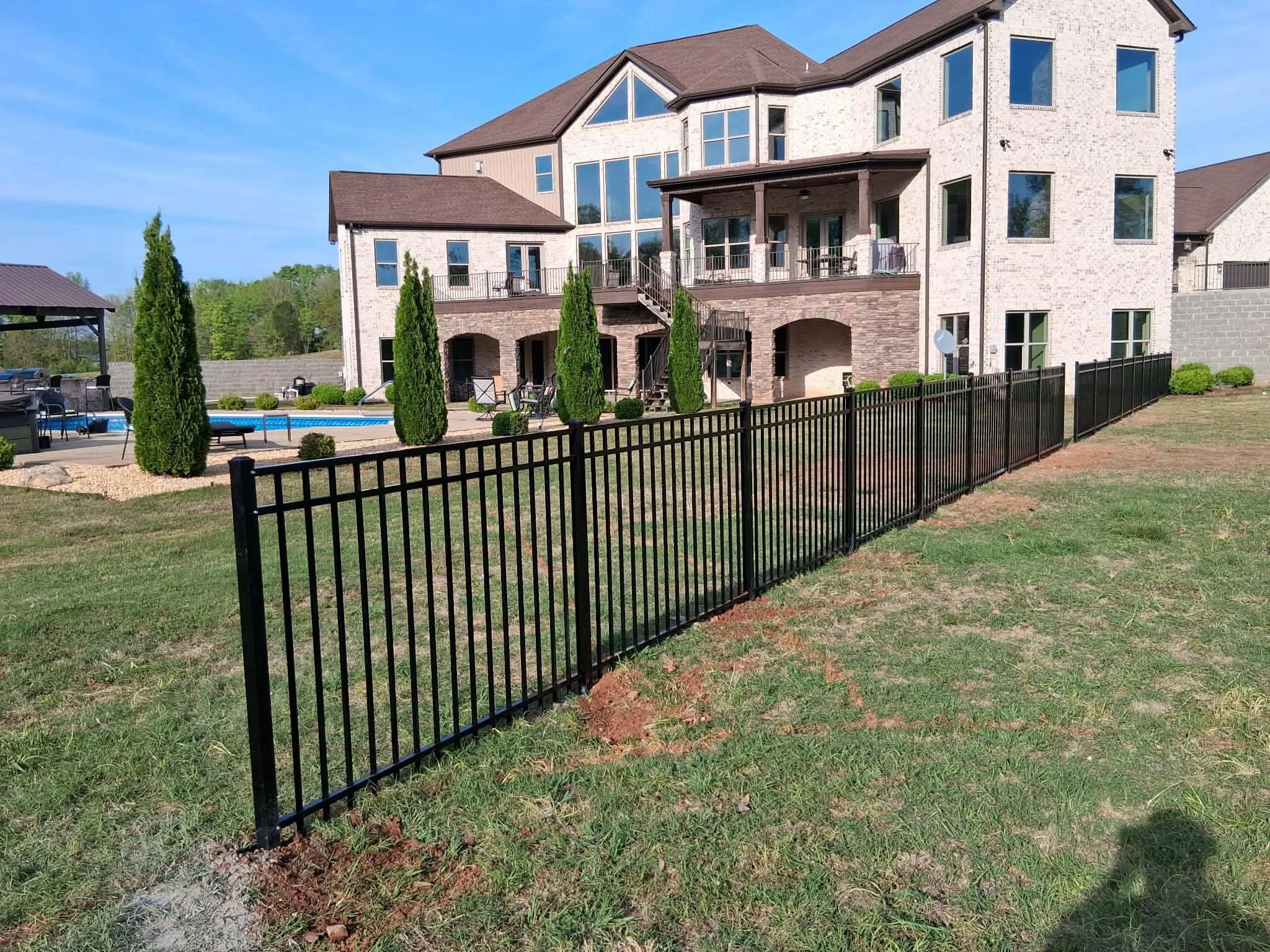 Black ornamental metal fence around a pool and patio in Muscle Shoals, AL