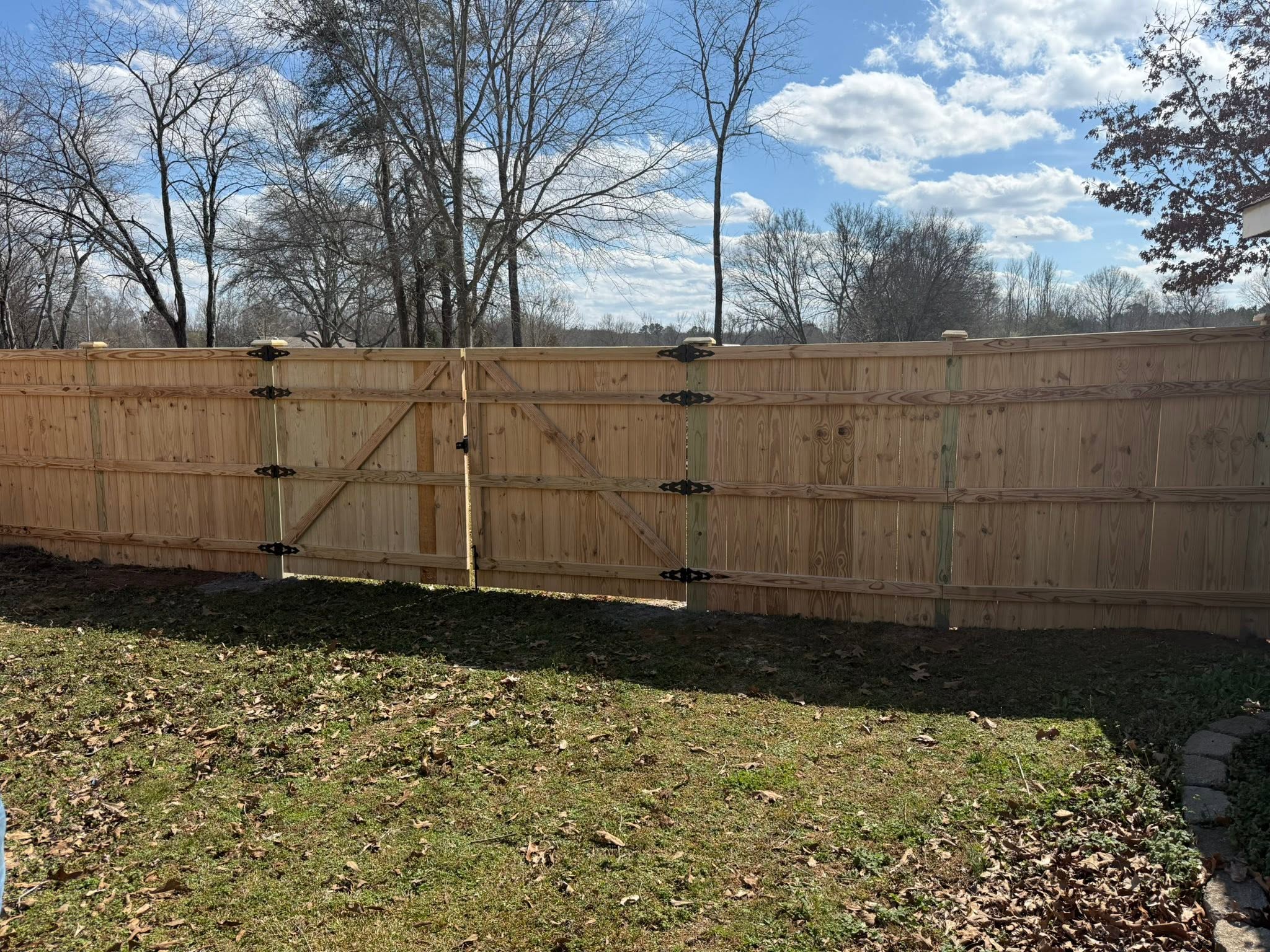 Wooden privacy fence with Z-brace double gate installation in Muscle Shoals, AL