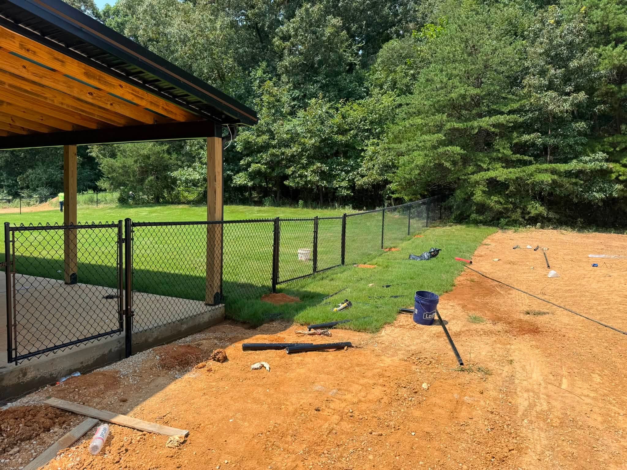 Black chain-link fence and gate beside a covered patio in Muscle Shoals, AL