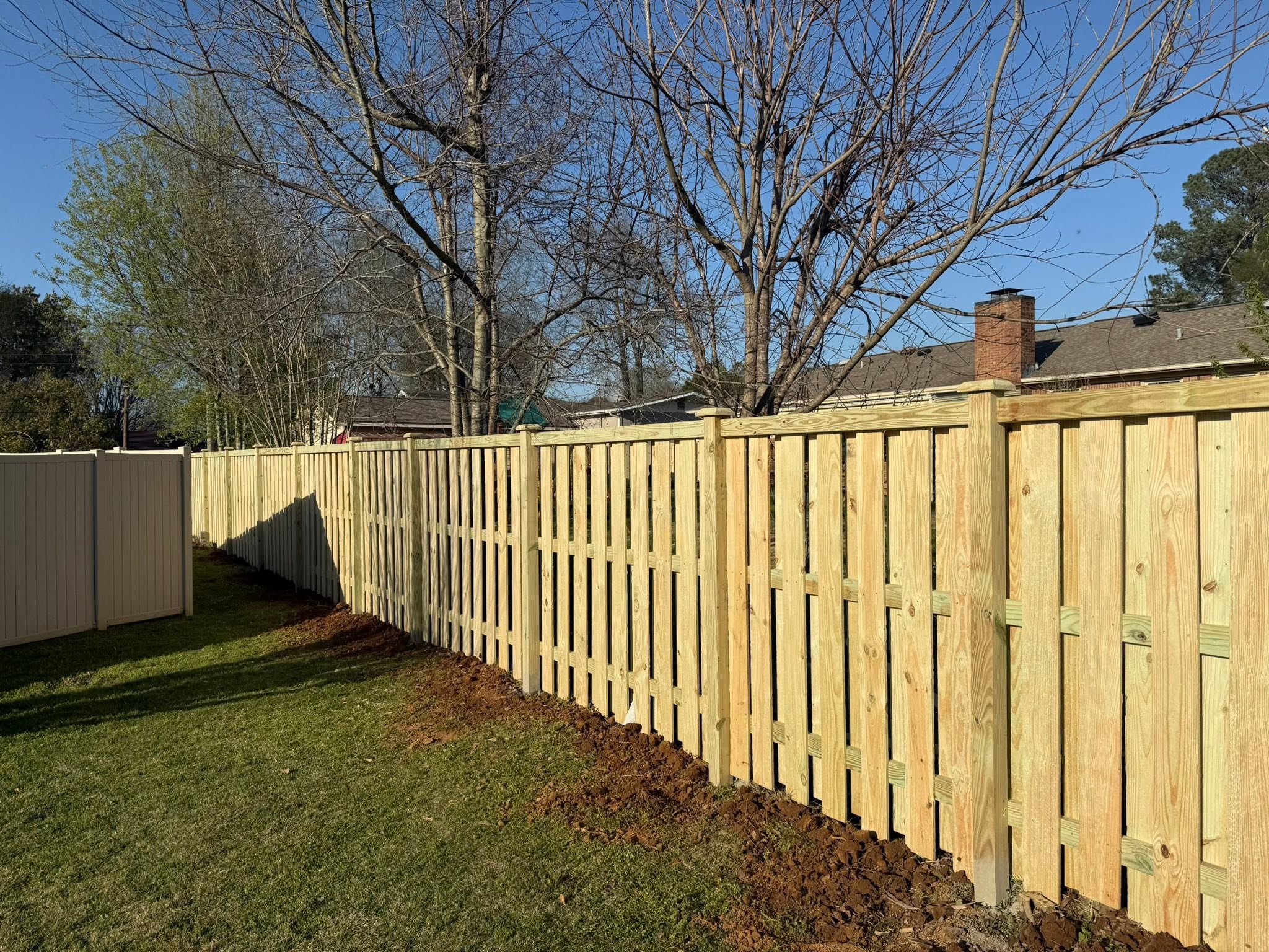 Board-on-board shadowbox wood privacy fence installation in Muscle Shoals, AL