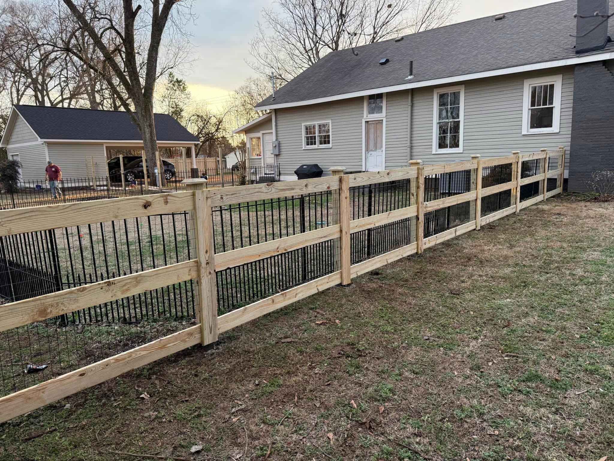 Hybrid wood-and-black-metal picket fence along a residential yard in Northern Alabama