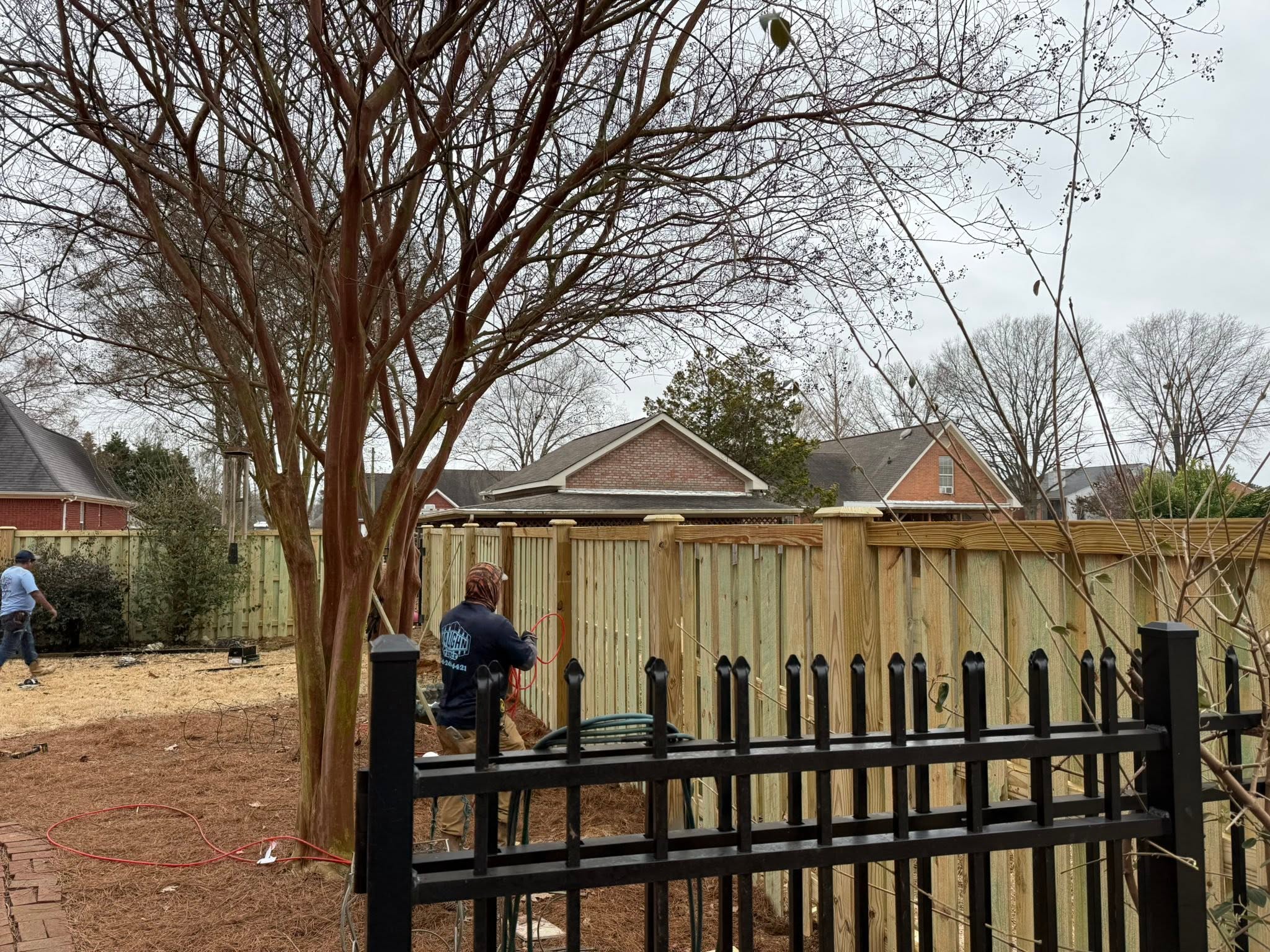 Vaughn Fence installer building a wood privacy fence near Muscle Shoals, AL