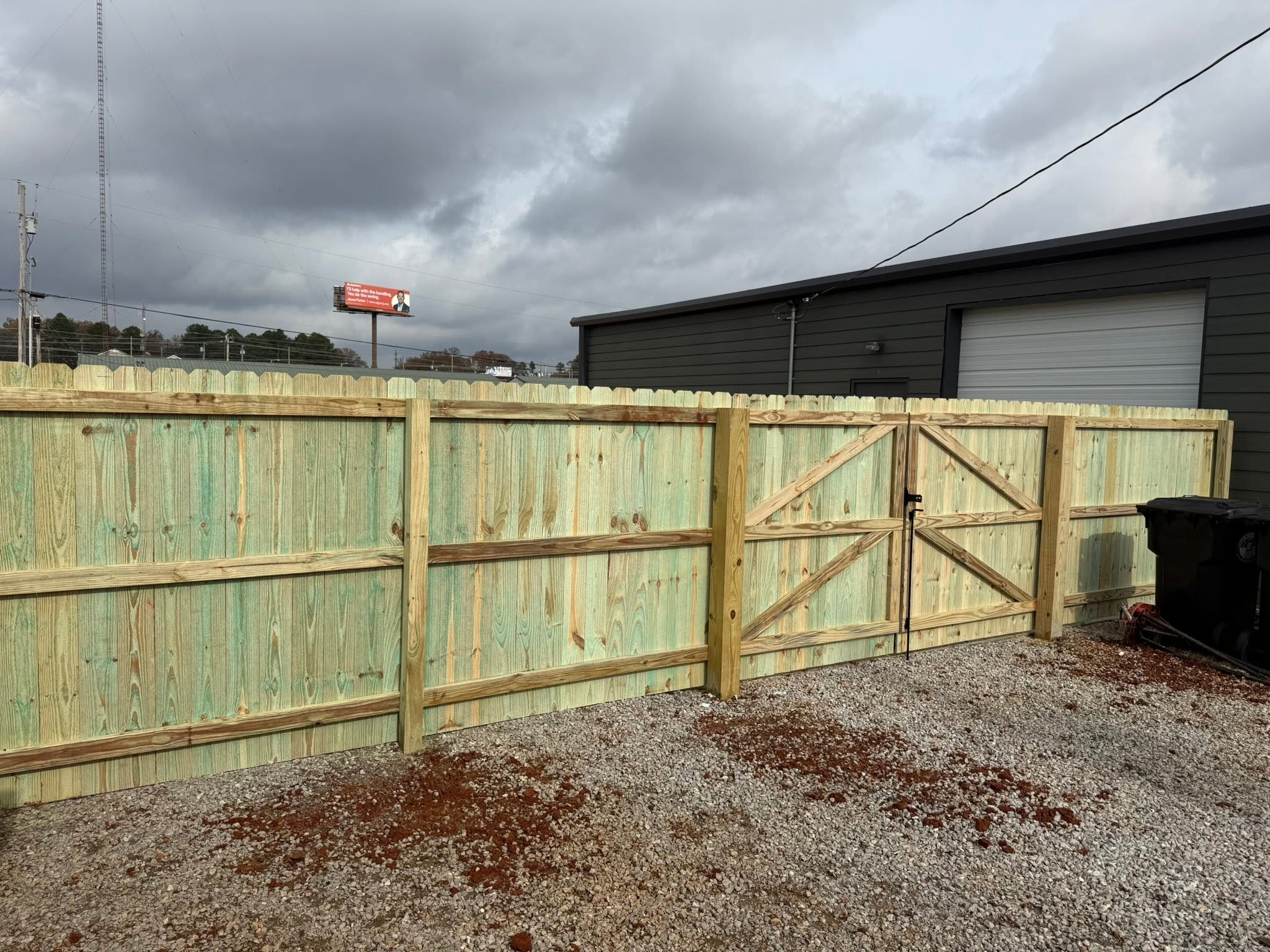 Pressure-treated wood privacy fence with X-brace double gate in the Shoals area