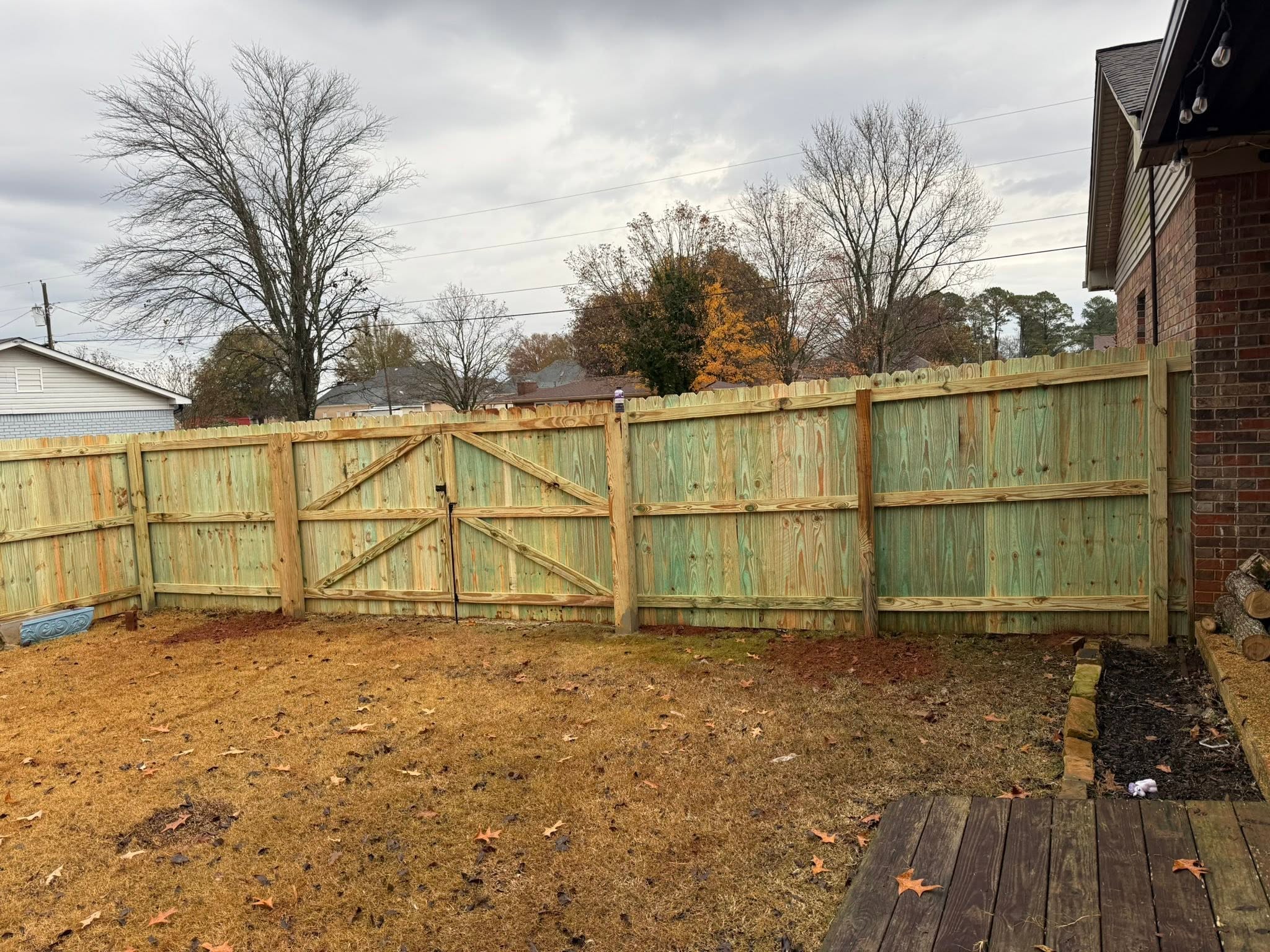 Backyard wood privacy fence and double gate installation in Muscle Shoals, AL
