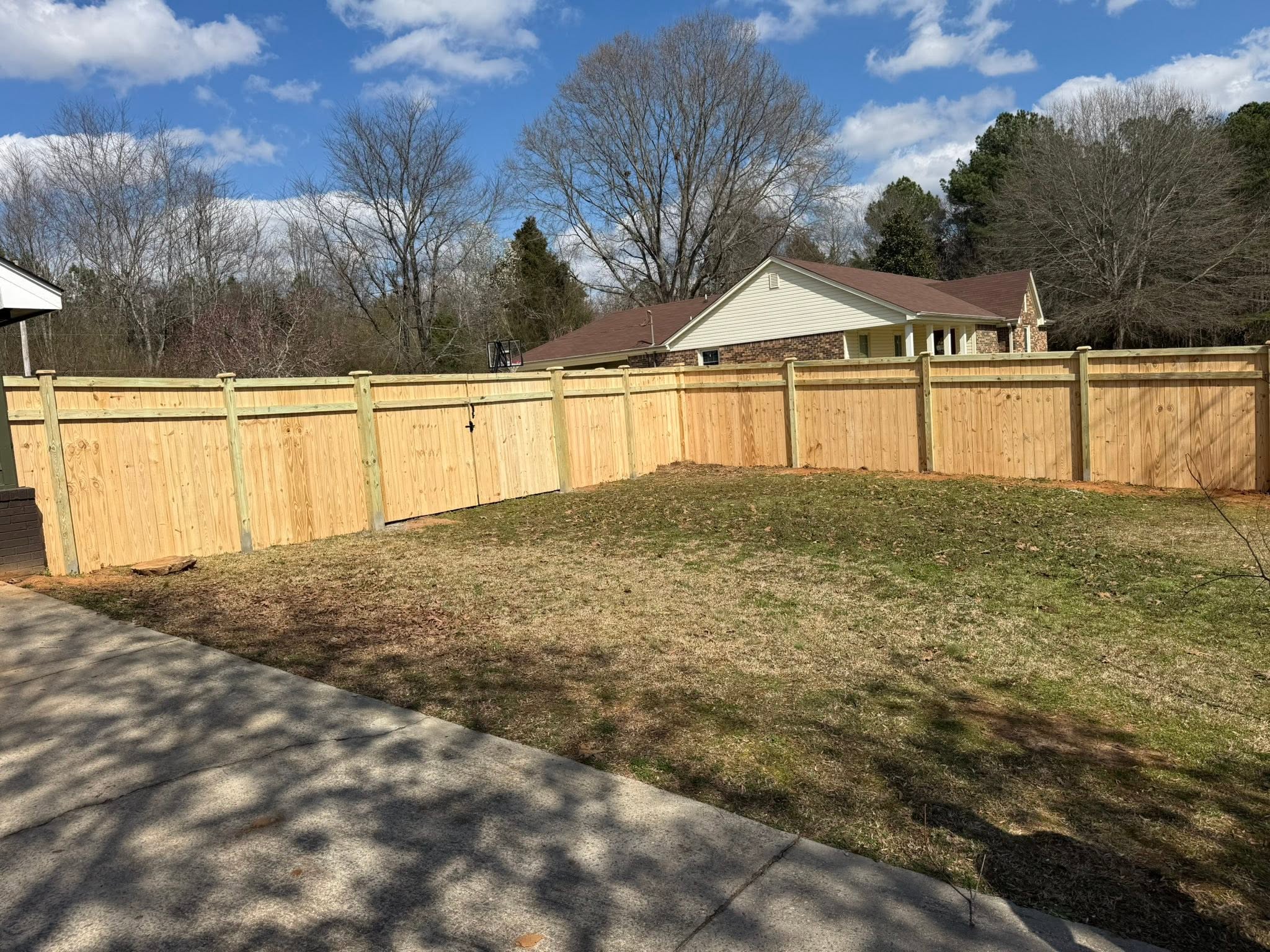 Completed wood privacy fence with double gate for a ranch home in Colbert County, AL
