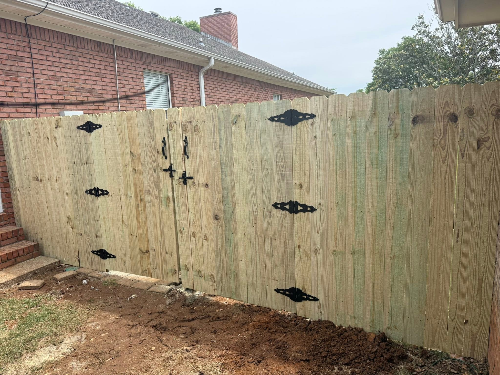Wood privacy fence double gate with decorative black hinges in Colbert County, AL