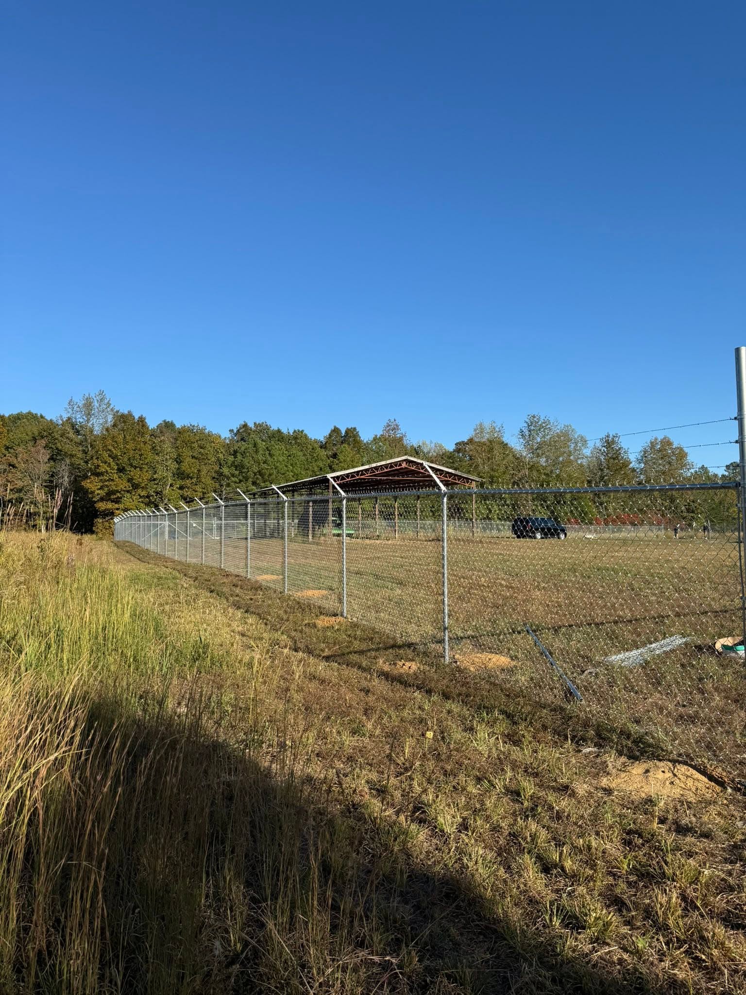 Chain-link perimeter fence with barbed wire for a commercial site near Muscle Shoals, AL