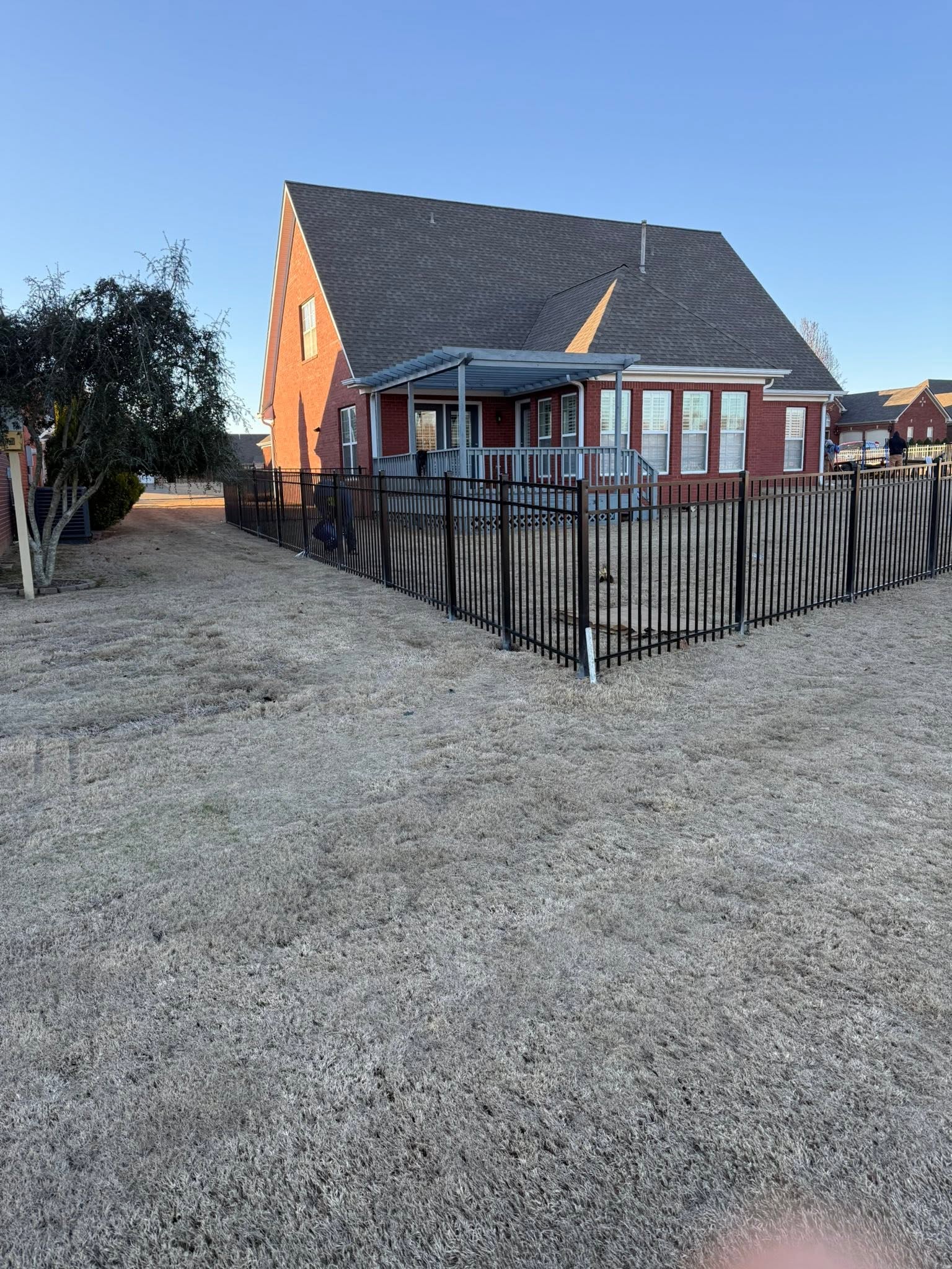 Black ornamental metal backyard fence around a brick home in Muscle Shoals, AL