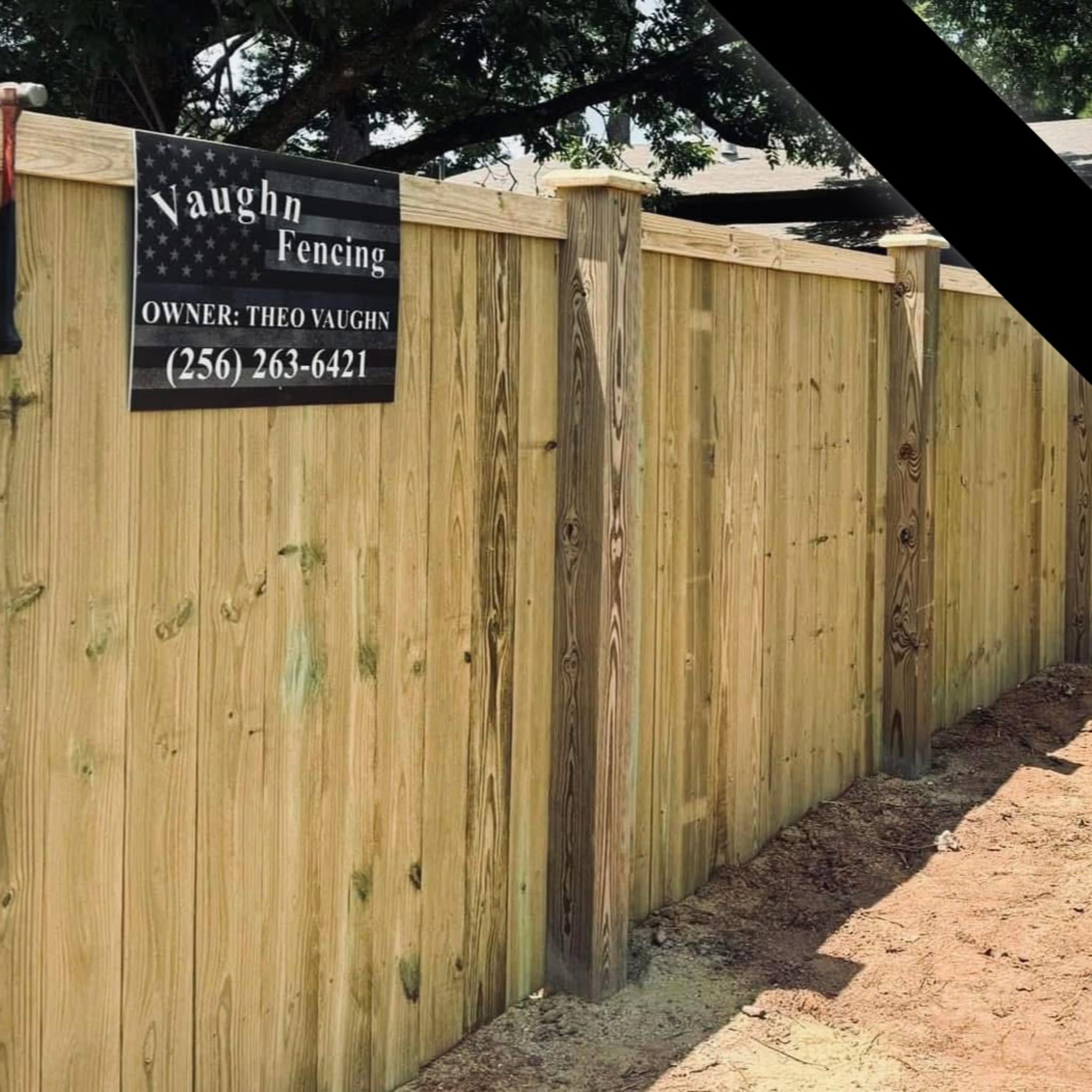Vaughn Fence job-site wood privacy fence with company sign in Muscle Shoals, AL