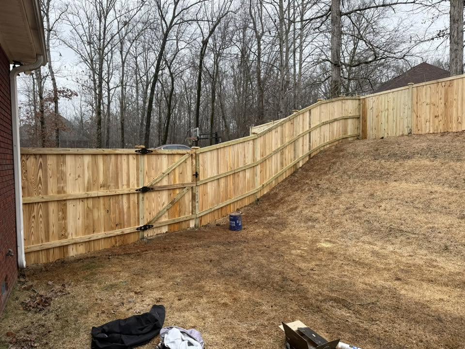 Wood privacy fence and double gate following a sloped yard in Northern Alabama